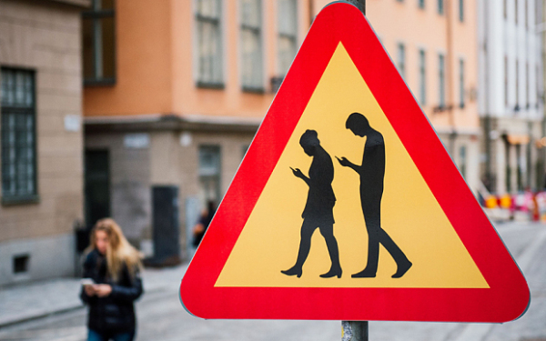 TOPSHOT - A road sign arning against pedestrians focusing on their smartphones is pictured on February 2, 2016 near the old town in Stockholm. / AFP / JONATHAN NACKSTRANDJONATHAN NACKSTRAND/AFP/Getty Images