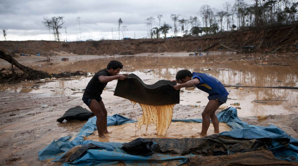 Men filter the mud in order to isolate sand as they mine for gold in La Pampa in the Madre de Dios region in Peru, Friday, May 2, 2014. People at the illegal gold mine are working up to the last minute while they fear authorities will arrive any moment as part of a government crackdown on illegal gold mining since a nationwide ban took effect April 19. (AP Photo/Rodrigo Abd)