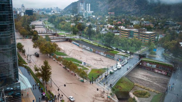View of the overflowing of the Mapocho river during heavy rains in Santiago on April 17, 2016. Four million people in Santiago were without tap water Sunday after unusually heavy rain pounding central Chile triggered landslides that fouled the city's water supply and forced the closure of the world's biggest copper mine, officials said. / AFP / VLADIMIR RODAS