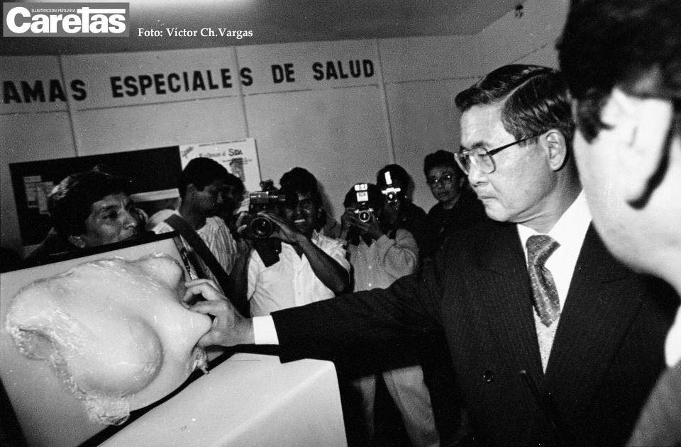 La mítica imagen de Fujimori aplastando un pezón de goma durante una campaña del Ministerio de Salud durante el decenio autoritario. Foto: Víctor Ch. Vargas/Caretas